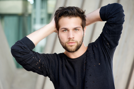 31695533 - close up portrait of a male fashion model posing with hands behind head