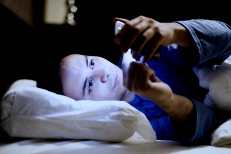 32258731 - man using his mobile phone in the bed