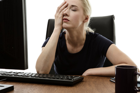 43401205 - woman sitting at her desk with her head in her hands stressed out
